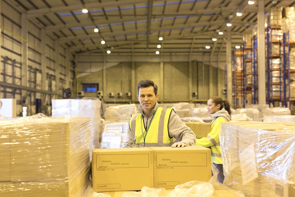 Worker unpacking boxes in warehouse